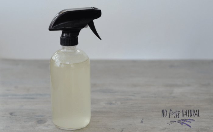 glass spray bottle filled with homemade green cleaning solution