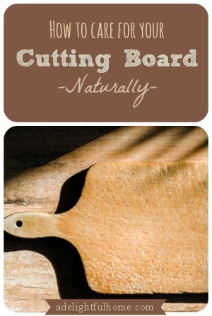 Image of a wooden paddle style cutting board sitting on top of a butcher block. Text overlay says, "How to Care for Your Cutting Board Naturally".