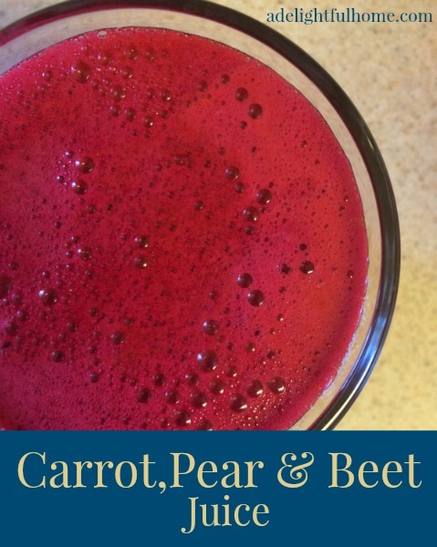 Bird's eye view of a glass of fresh pressed juice. Text overlay says, "Carrot, Pear, and Beet Juice".