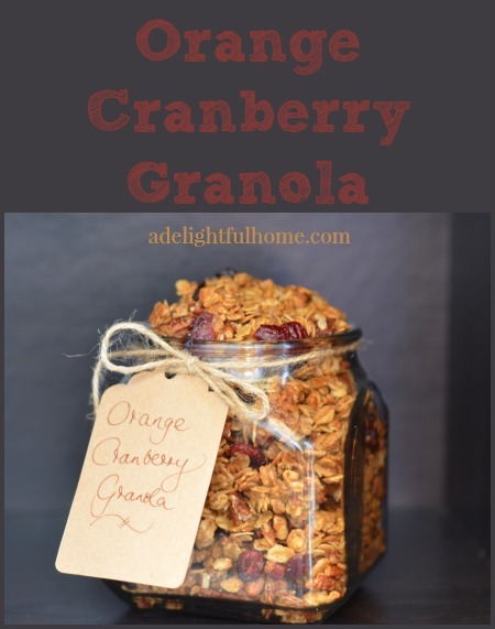 Square jar filled with homemade granola. Text overlay says, "Orange Cranberry Granola".