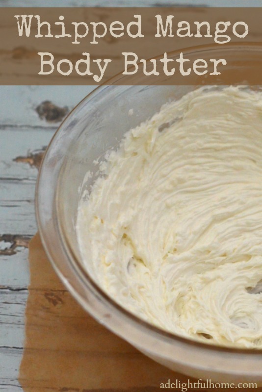 A close up image of a bowl of whipped mango butter on a whitewashed table. Text overlay says, "Whipped Mango Body Butter".