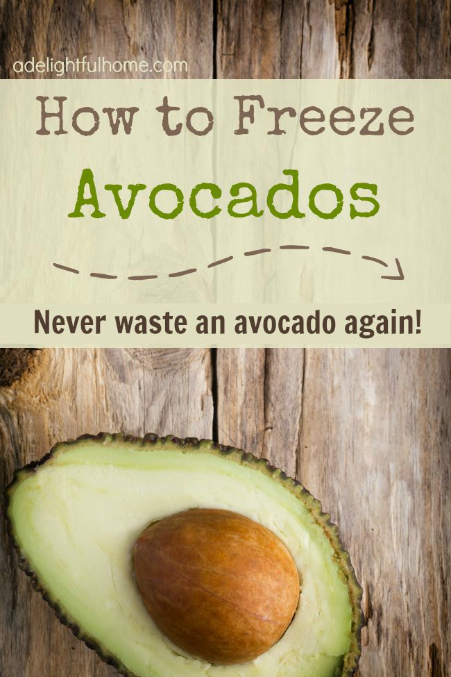 Halved avocado against a natural wood background. Text overlay says, "How to Freeze Avocados - Never Waste an Avocado Again".
