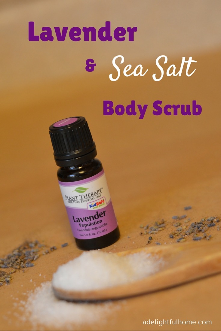 Image of a bottle of lavender essential oil. A wooden spoon filled with sea salt sits in the foreground. Lavender flowers are scattered about for decorative effect. Text overlay says, "Lavender & Sea Salt Body Scrub".