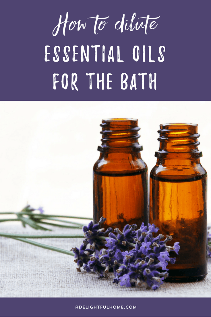 Two opened amber essential oil bottles sitting behind a fresh sprig of lavender. Text overlay says, "How to Dilute Essential Oils for the Bath".