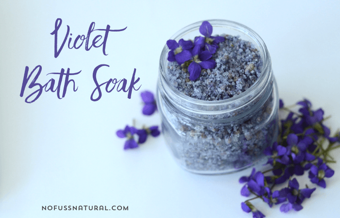 purple sea salt with violets in a glass jar for bath soak
