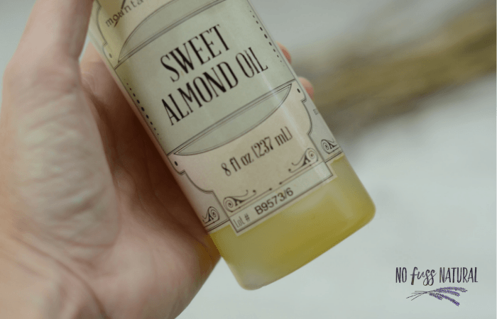 Holding bottle of sweet almond oil to show color