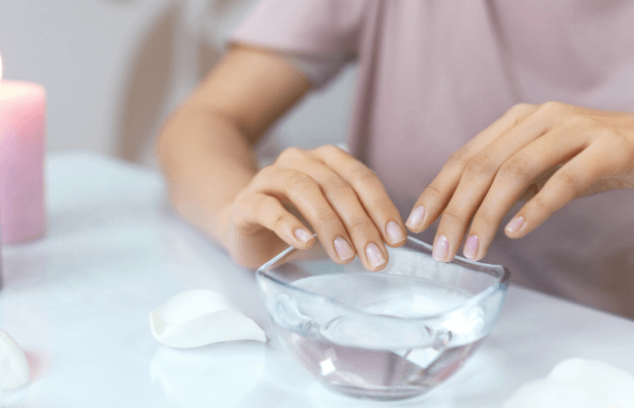 hands over a bowl of water to perform a nail soak